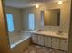 Bathroom with double sinks and a bathtub at 34303 Lodge Dr, Wesley Chapel, FL 33543