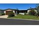 Tan single-wide manufactured home with attached garage at 34303 Lodge Dr, Wesley Chapel, FL 33543