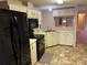 Galley kitchen with black appliances and light-colored cabinets at 34303 Lodge Dr, Wesley Chapel, FL 33543