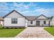 Modern farmhouse exterior with gray accents, a paver driveway, and landscaped lawn at 4080 Southern Valley Loop, Brooksville, FL 34601