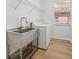 Laundry room with utility sink, washer, dryer, and overhead shelving at 18051 Java Isle Dr, Tampa, FL 33647