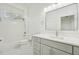 Modern bathroom with gray vanity, white tile, and a large mirror at 18051 Java Isle Dr, Tampa, FL 33647