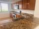 Bright kitchen featuring granite counters, wood cabinets, and stainless steel appliances at 19111 Vista Bay Dr # 308, Indian Shores, FL 33785