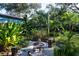 Relaxing backyard with fire pit and lush tropical landscaping at 2406 S Clark Ave, Tampa, FL 33629