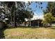 Expansive backyard with mature trees, privacy fence, and a lovely screened-in porch at 7140 Orchid Lake Rd, New Port Richey, FL 34653