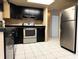 Updated kitchen featuring stainless steel appliances, dark cabinetry and tile floor at 7140 Orchid Lake Rd, New Port Richey, FL 34653