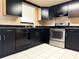 Updated kitchen featuring stainless steel appliances, dark cabinetry and tile floor at 7140 Orchid Lake Rd, New Port Richey, FL 34653