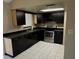 Updated kitchen featuring stainless steel appliances, dark cabinetry and tile floor at 7140 Orchid Lake Rd, New Port Richey, FL 34653