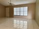 Bright living room with tile flooring, large window and ceiling fan at 7140 Orchid Lake Rd, New Port Richey, FL 34653