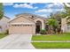 Two-story house with a two-car garage, landscaping, and palm trees at 30552 Latourette Dr, Wesley Chapel, FL 33545