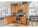 Kitchen with light wood cabinets, stainless steel appliances, and a view of dining area at 30552 Latourette Dr, Wesley Chapel, FL 33545