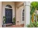 Black front door with arched window and potted plants at 30552 Latourette Dr, Wesley Chapel, FL 33545