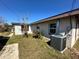 Rear view of the house with AC unit and yard at 620 Dalton Blvd, Port Charlotte, FL 33952