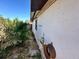 Side of the house with a rusty wheel and small plants at 620 Dalton Blvd, Port Charlotte, FL 33952