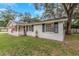 White brick ranch home with black shutters, covered porch, and American flag at 15901 Manning Dr, Tampa, FL 33613