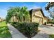 Two-story house with a two-car garage, lush landscaping, and a charming walkway at 5648 Sunset Falls Dr, Apollo Beach, FL 33572