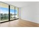 Bright bedroom with hardwood floors and sliding glass doors leading to a balcony with city views at 1000 Water St # 1402, Tampa, FL 33602