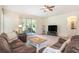 Relaxing living room with brown sofas and a wooden coffee table, providing access to a screened porch at 10954 May Apple Ct, Land O Lakes, FL 34638