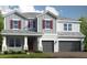 Two-story home with gray siding, red shutters, and a three-car garage at 16212 Alpha Grove Pl, Odessa, FL 33556
