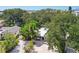 Aerial view of a lush property with mature trees, a well-manicured lawn, and a glimpse of the ocean in the background at 1906 2Nd St, Indian Rocks Beach, FL 33785