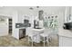 Modern kitchen with stainless steel appliances, breakfast bar, white cabinetry, tile backsplash, and wood floors at 1906 2Nd St, Indian Rocks Beach, FL 33785