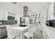 Bright kitchen features white cabinetry, stainless steel appliances, an island with seating, and outdoor access at 1906 2Nd St, Indian Rocks Beach, FL 33785
