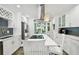 Bright kitchen features white cabinetry, stainless steel appliances, an island with seating, and outdoor access at 1906 2Nd St, Indian Rocks Beach, FL 33785