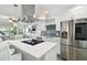 Bright kitchen features white cabinetry, stainless steel appliances, and an island with seating at 1906 2Nd St, Indian Rocks Beach, FL 33785