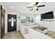 Cozy living room featuring a ceiling fan, wood floors, a comfortable sofa and lots of natural light at 1906 2Nd St, Indian Rocks Beach, FL 33785