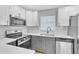 Modern kitchen with white and gray cabinets, quartz countertops at 3202 E Elm St, Tampa, FL 33610