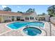 Sparkling swimming pool with attached spa, surrounded by a paved patio and manicured landscaping at 4608 Apple Ridge Ln, Tampa, FL 33624