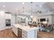 Open concept kitchen with island, stainless steel appliances, and hardwood floors at 16240 Alpha Grove Pl, Odessa, FL 33556