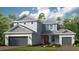 Two-story home with gray siding, red door, and two-car garage at 16240 Alpha Grove Pl, Odessa, FL 33556