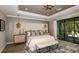 Luxurious main bedroom with a plush bed, access to a screened-in patio, and plenty of natural light at 11178 Manor House Ln, Odessa, FL 33556