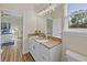 Main bathroom features a granite vanity, and a view into a bedroom at 6435 Finance Ave, Weeki Wachee, FL 34607