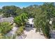 Aerial view of a charming house with lush tropical landscaping and a large driveway at 1906 2Nd St, Indian Rocks Beach, FL 33785