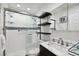 Clean bathroom with walk-in shower, marble vanity, and shelves at 1906 2Nd St, Indian Rocks Beach, FL 33785