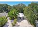 Aerial view of a charming house with lush tropical landscaping and a large driveway at 1906 2Nd St, Indian Rocks Beach, FL 33785