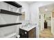 Bathroom with marble vanity, toilet, and view of hallway at 1906 2Nd St, Indian Rocks Beach, FL 33785