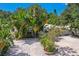 Aerial view of a charming house with lush tropical landscaping and a large driveway at 1906 2Nd St, Indian Rocks Beach, FL 33785