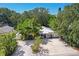 Aerial view of a charming house with lush tropical landscaping and a large driveway at 1906 2Nd St, Indian Rocks Beach, FL 33785