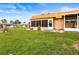 Backyard view of condo with screened patio and grassy area at 1801 Bedford Ln # 27, Sun City Center, FL 33573