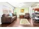 Living room with dark brown leather furniture, hardwood floors, and kitchen view at 1801 Bedford Ln # 27, Sun City Center, FL 33573