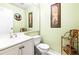 Small bathroom with white vanity, toilet, and decorative wall art at 1801 Bedford Ln # 27, Sun City Center, FL 33573