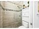Bathroom features a glass shower, tiled walls, and a built-in storage cabinet at 7925 Royal Queensland Way, Lakewood Ranch, FL 34202