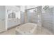 Elegant bathroom with a soaking tub, walk-in shower, and spacious vanity area at 7925 Royal Queensland Way, Lakewood Ranch, FL 34202