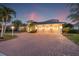 Stunning home featuring a three-car garage, a spacious driveway, and lush landscaping at 7925 Royal Queensland Way, Lakewood Ranch, FL 34202