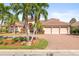 Beautiful home with lush landscaping, a brick driveway, and a three-car garage for ample parking at 7925 Royal Queensland Way, Lakewood Ranch, FL 34202