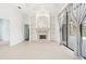 Sunlit living room features a fireplace with built-in shelving and a sliding glass door at 7925 Royal Queensland Way, Lakewood Ranch, FL 34202