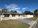 Ranch-style home with gray driveway, white fence, and mature landscaping at 805 64Th N Ave, St Petersburg, FL 33702